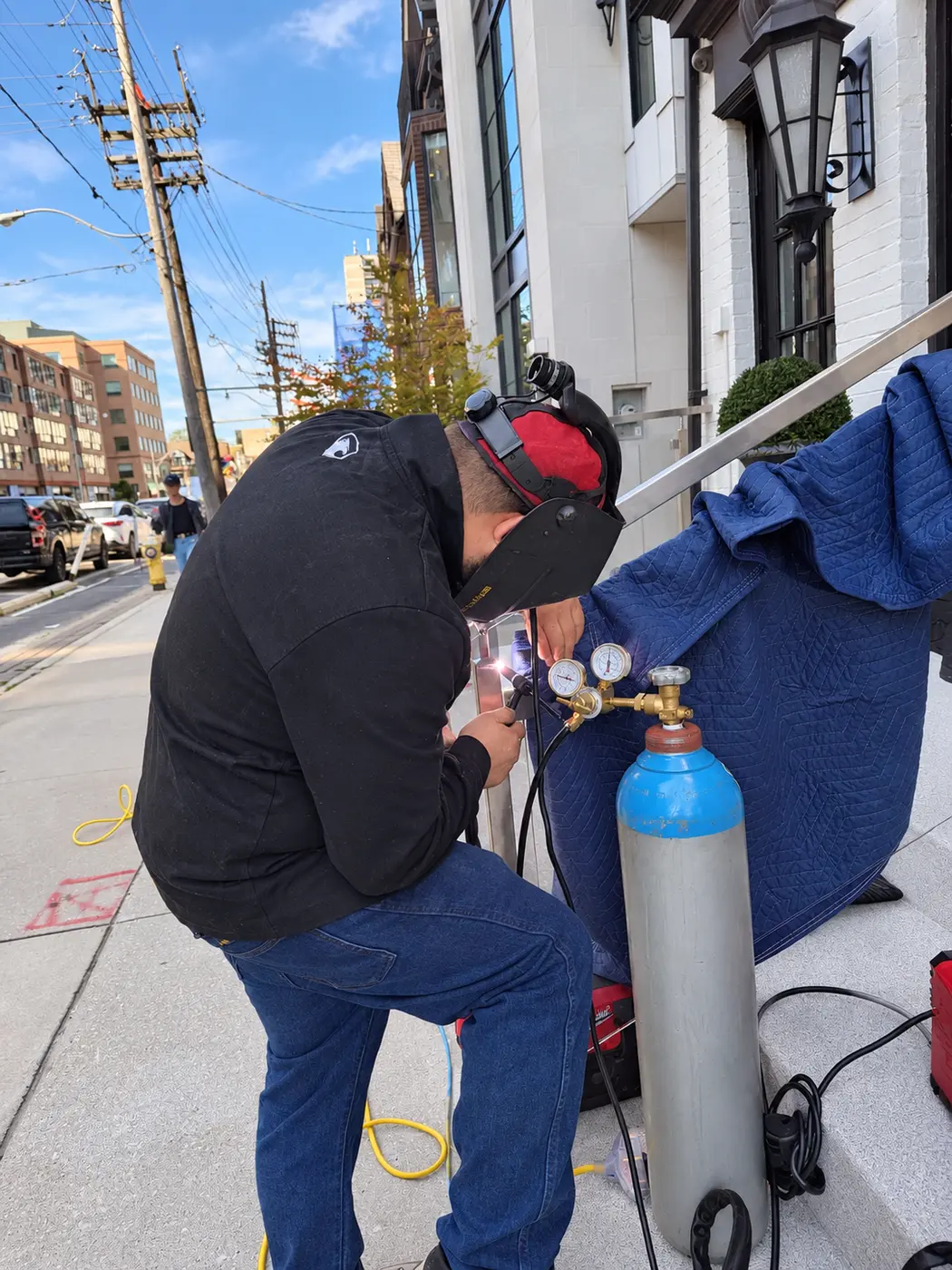 Mobile welding beside a railing with shielding gas and protective blankets
