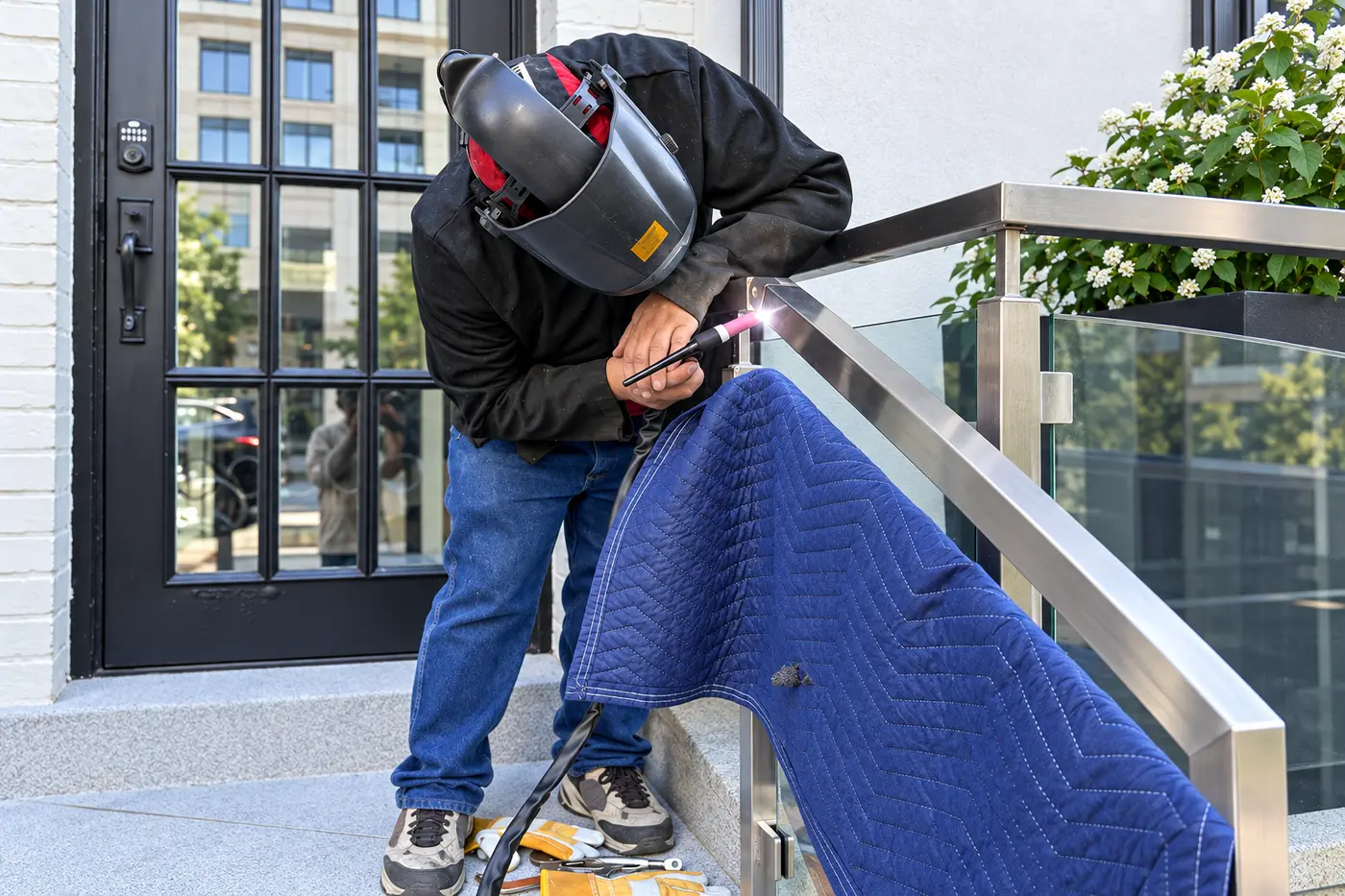 Welder TIG welding a stainless steel railing at a customer site